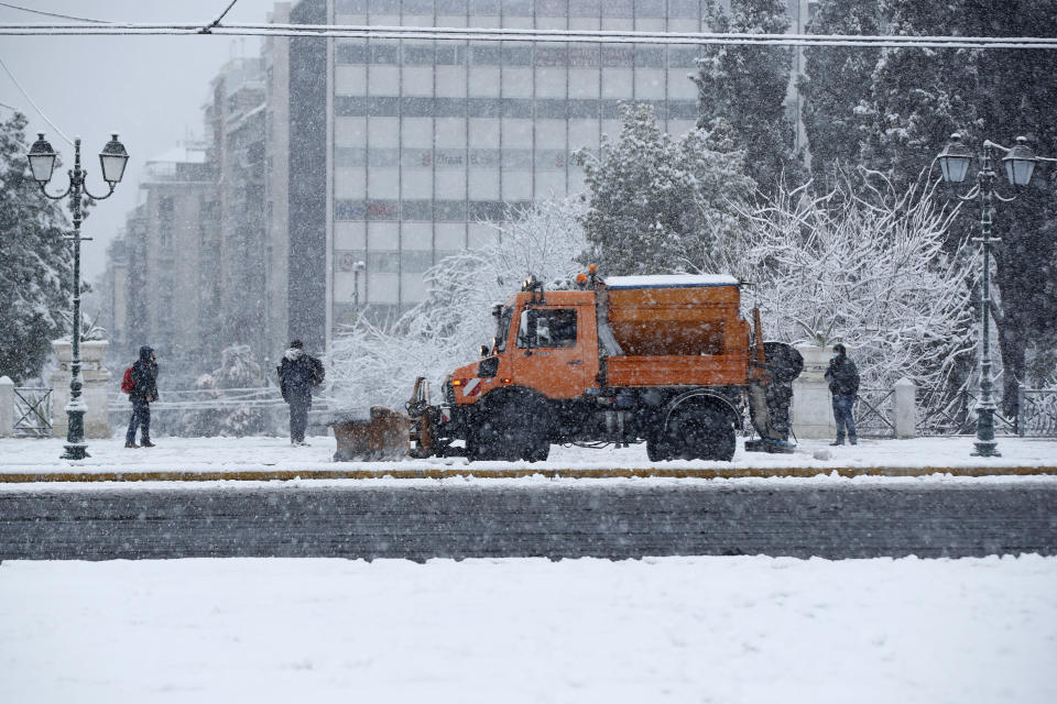 A snowplough cleans a main avenue at Syntagma square during a heavy snowfall in central Athens, Tuesday, Feb.16, 2021. Unusually heavy snowfall has blanketed central Athens, with authorities warning residents particularly in the Greek capital's northern and eastern suburbs to avoid leaving their homes. (AP Photo/Thanassis Stavrakis)