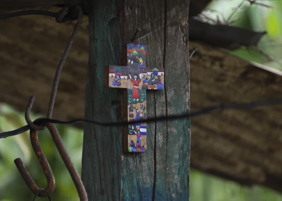 A cross hangs at the home of siblings Gisel and Brayan, in Berlin, El Salvador, Wednesday, March 1, 2023. The teenager and her 8-year-old were left without guardians six months prior when police came for her parents after receiving an anonymous tip during the government's "state of exception" that targeted alleged gang members. Their aunt arrived from the capital to care for them, giving up her job to do so, and their extended family pools money. (AP Photo/Salvador Melendez)
