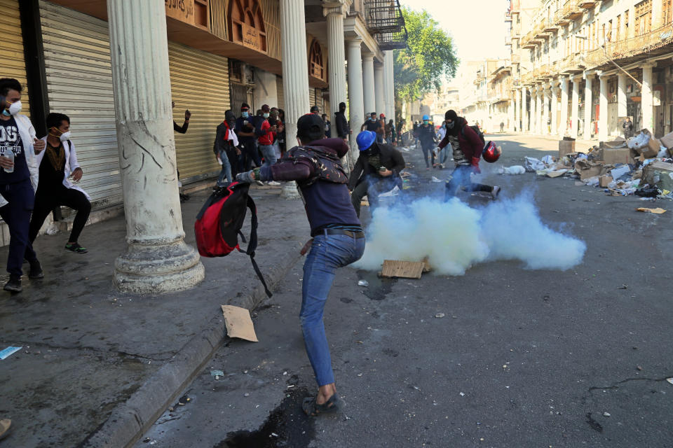 Riot police fire tear gas during clashes with anti-government demonstrators in Baghdad, Iraq, Friday, Nov. 22, 2019. Iraq's massive anti-government protest movement erupted Oct. 1 and quickly escalated into calls to sweep aside Iraq's sectarian system. Protesters occupy several Baghdad squares and parts of three bridges in a standoff with security forces. (AP Photo/Hadi Mizban)