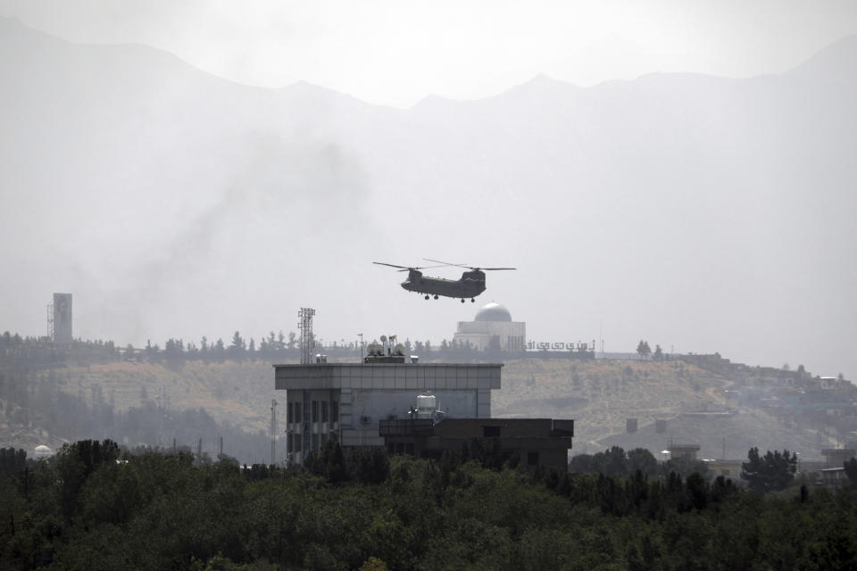 A U.S. Chinook helicopter flies over the U.S. Embassy in Kabul, Afghanistan, Sunday, Aug. 15, 2021. Helicopters are landing at the U.S. Embassy in Kabul as diplomatic vehicles leave the compound amid the Taliban advanced on the Afghan capital. (AP Photo/Rahmat Gul)