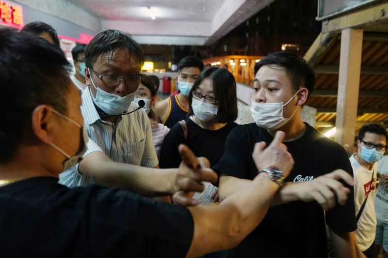 Pro-Beijing activist hurls insults at Roy Tam Hoi-pong and his volunteer during a campaign for the primary election aimed at selecting democracy candidates for the September election, in Hong Kong