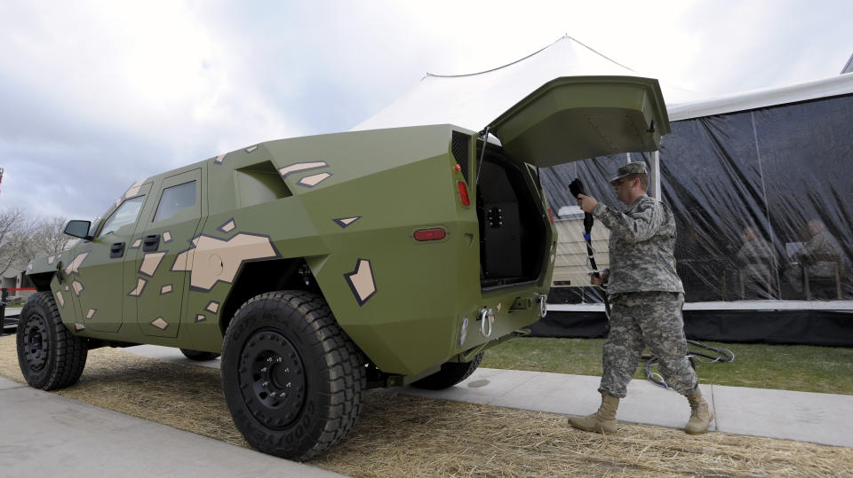 Captain Robert Shaw plugs a cord into this Fuel Efficient Demonstrator vehicle (FED) named, "BRAVO" to power electronics in the grand-opening tent, Wednesday, April 11, 2012 in Warren, Mich. The U.S. Army unveiled a new laboratory Wednesday that can simulate Afghanistan's desert heat and Antarctica's extreme cold in an effort to discover how to save energy and make combat vehicles fuel-efficient. (AP Photo/Detroit News, Todd McInturf ) DETROIT FREE PRESS OUT; HUFFINGTON POST OUT