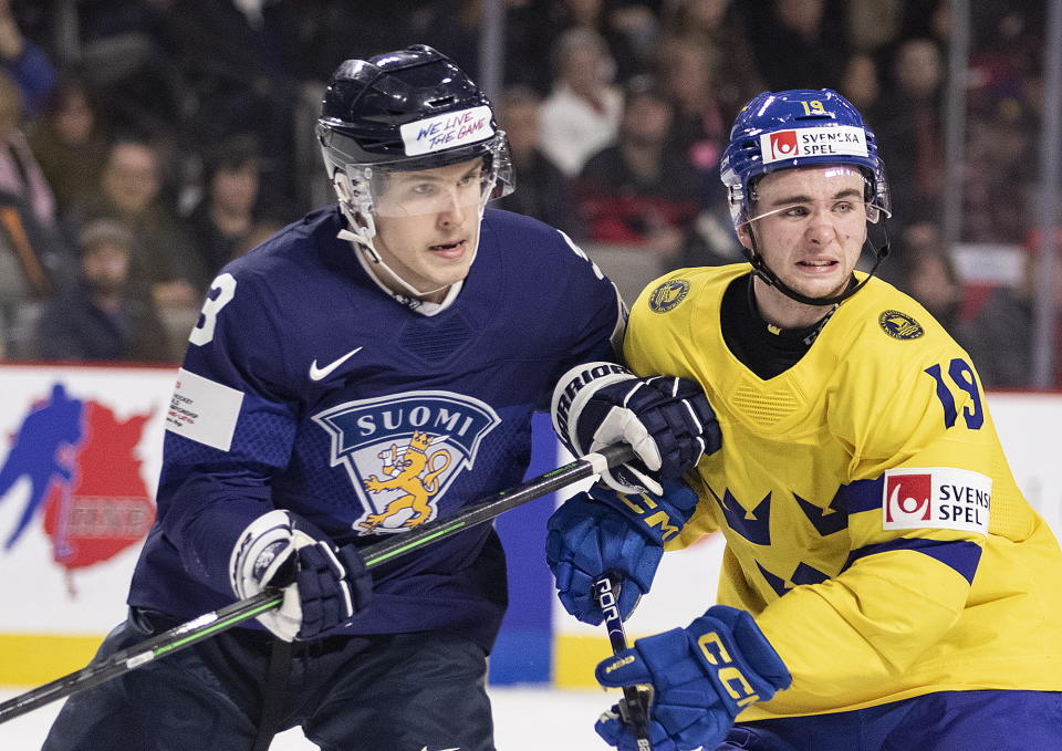 Finland's Otto Salin, left, and Sweden's Isak Rosen watch the play during the third period of a quarterfinal hockey match at the world junior championship in Moncton, New Brunswick, Monday, Jan. 2, 2023. (Ron Ward/The Canadian Press via AP)