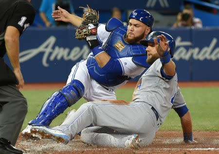 Sep 20, 2017; Toronto, Ontario, CAN; Kansas City Royals left fielder Alex Gordon (4) slides safely home to score under the tag of Toronto Blue Jays catcher Russell Martin (55) in the second inning at Rogers Centre. Mandatory Credit: Dan Hamilton-USA TODAY Sports