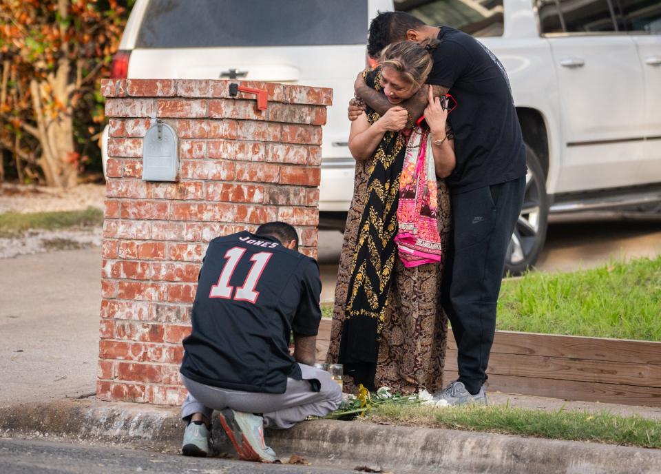 Family members mourn at a memorial set up in front of the home of a woman who was shot on Shadywood Drive in Austin as part of a multicounty wave of violence that left six dead and three injured last week.