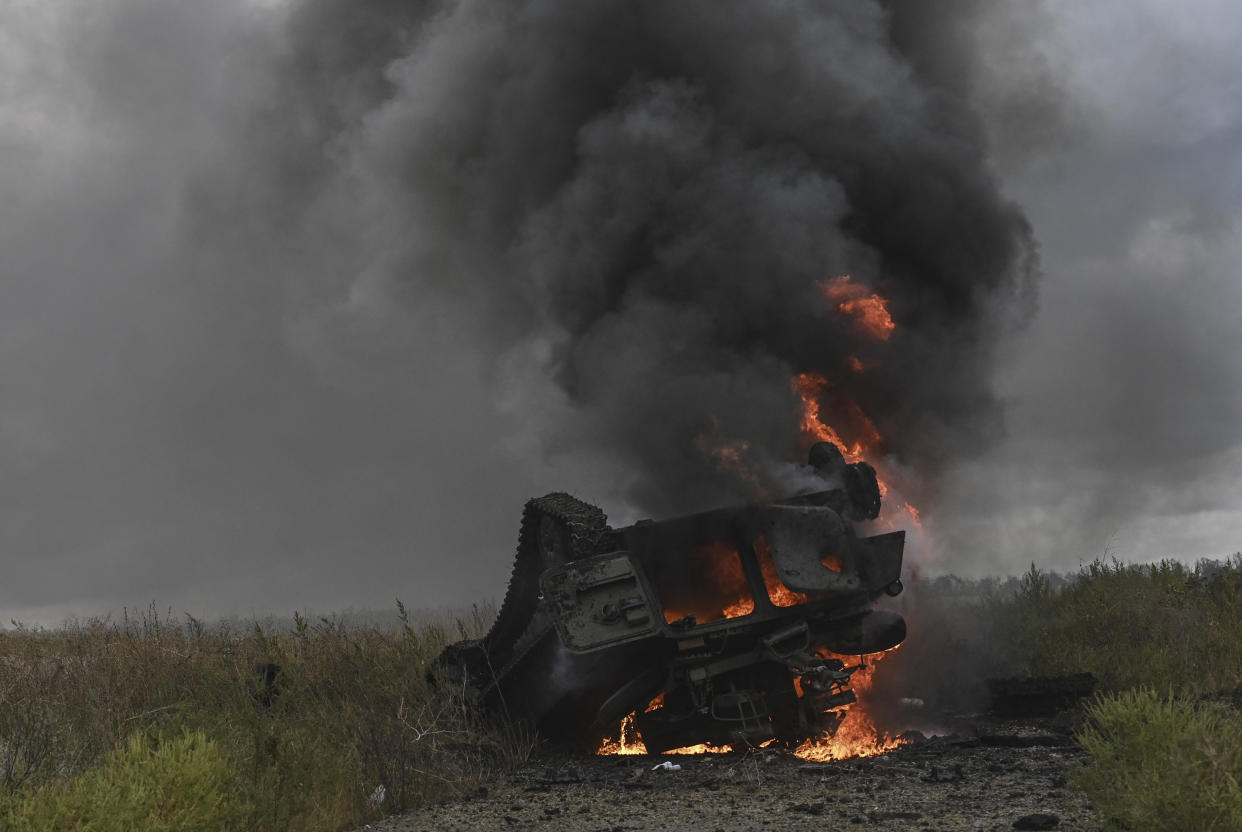 This photograph taken on September 14, 2022 shows a destroyed Russian MT-LB armoured personnel carrier burning in a field on the outskirts of Izyum, Kharkiv Region, eastern Ukraine amid the Russian invasion of Ukraine. (Photo by Juan BARRETO / AFP) (Photo by JUAN BARRETO/AFP via Getty Images)
