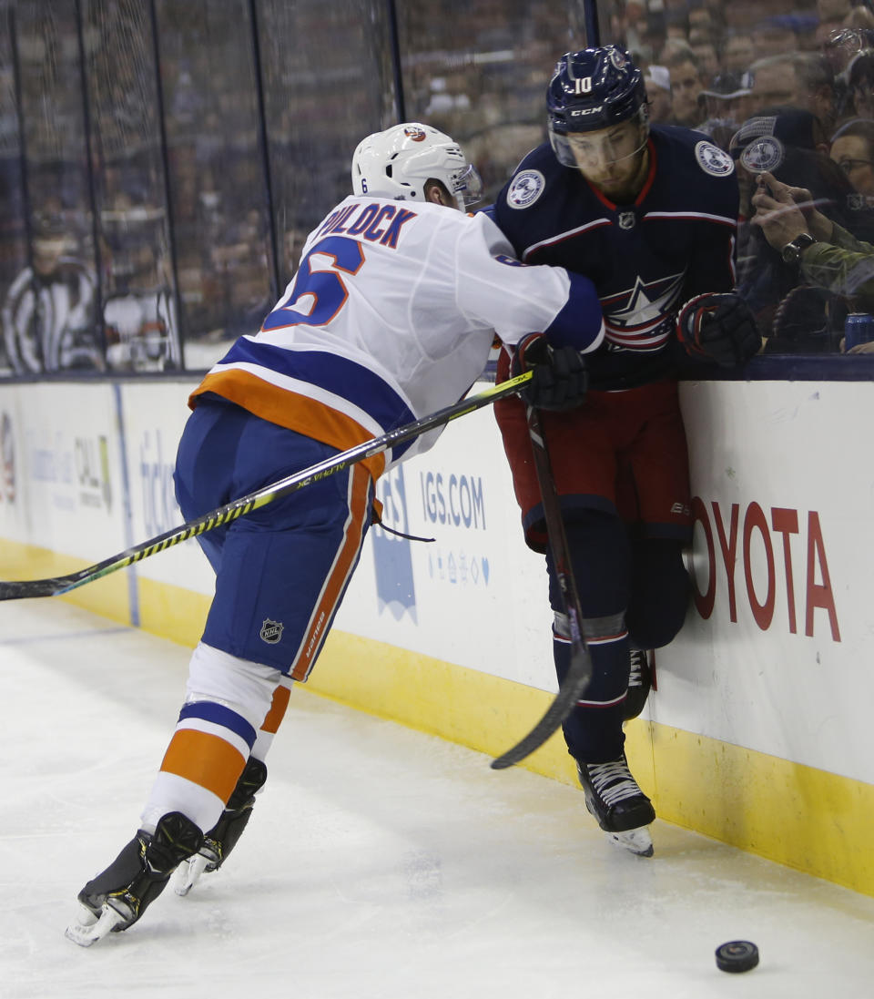 New York Islanders' Ryan Pulock, left, checks Columbus Blue Jackets' Alexander Wennberg, of Sweden, during the second period of an NHL hockey game Thursday, Feb. 14, 2019, in Columbus, Ohio. (AP Photo/Jay LaPrete)