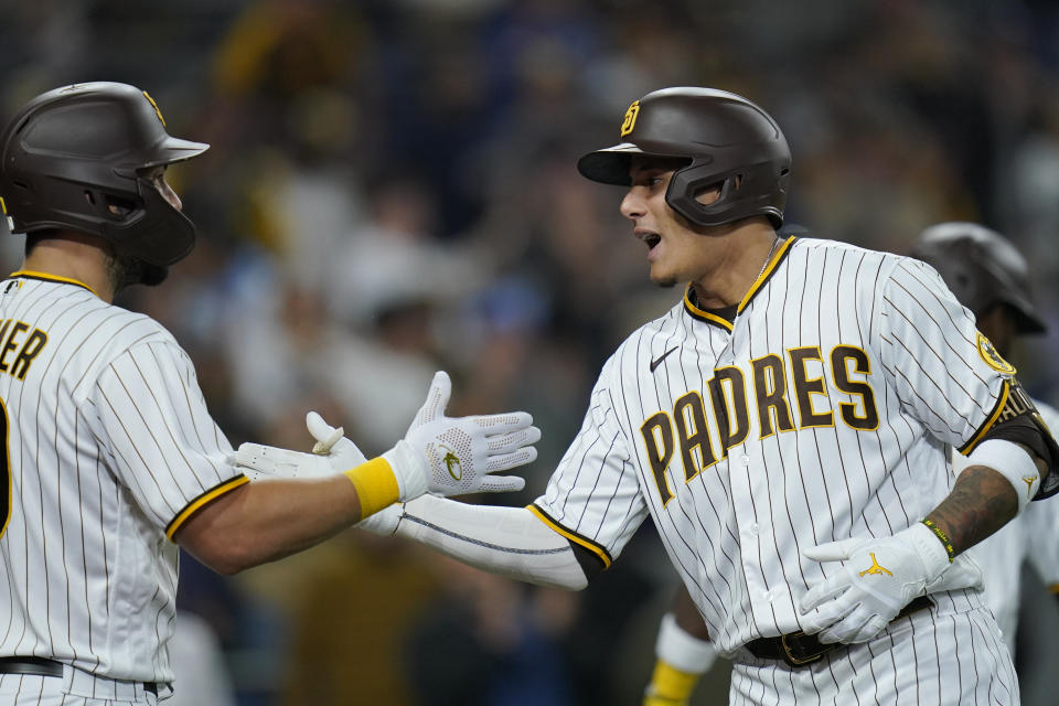 San Diego Padres' Manny Machado, right, is greeted by teammate Eric Hosmer after hitting a home run during the fourth inning of a baseball game against the Miami Marlins, Thursday, May 5, 2022, in San Diego. (AP Photo/Gregory Bull)