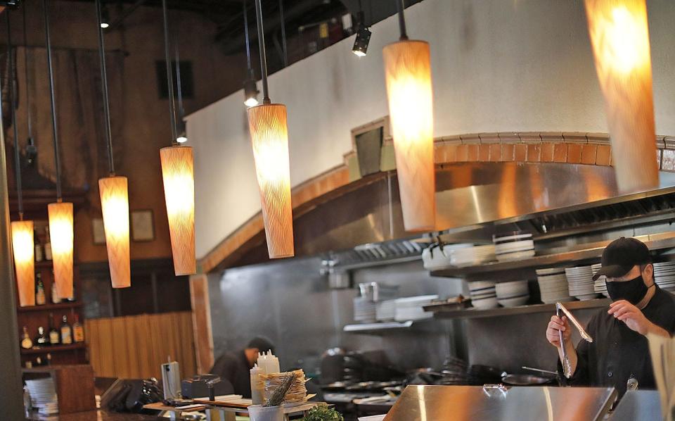 The open-concept kitchen stands front and center in the main dining room at Tosca in Hingham. Greg Derr/ The Patriot Ledger