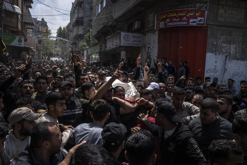 Mourners carry the bodies of Palestinians who were killed in Israeli airstrikes, during their funeral in Gaza City, Tuesday, May 9, 2023. The airstrikes killed three senior commanders of the militant Islamic Jihad group and 10 other people, including two of the commanders' wives, several of their children and others nearby. (AP Photo/Fatima Shbair)