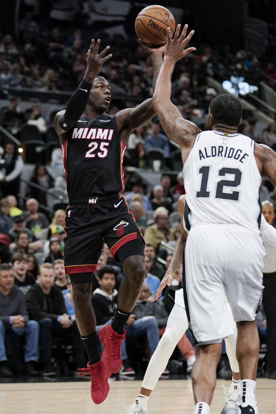 Miami Heat's Kendrick Nunn (25) shoots against San Antonio Spurs' LaMarcus Aldridge during the first half of an NBA basketball game, Sunday, Jan. 19, 2020, in San Antonio. (AP Photo/Darren Abate)