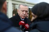 Turkish President Tayyip Erdogan talks to journalists in front of a mosque as he leaves friday prayers in Istanbul