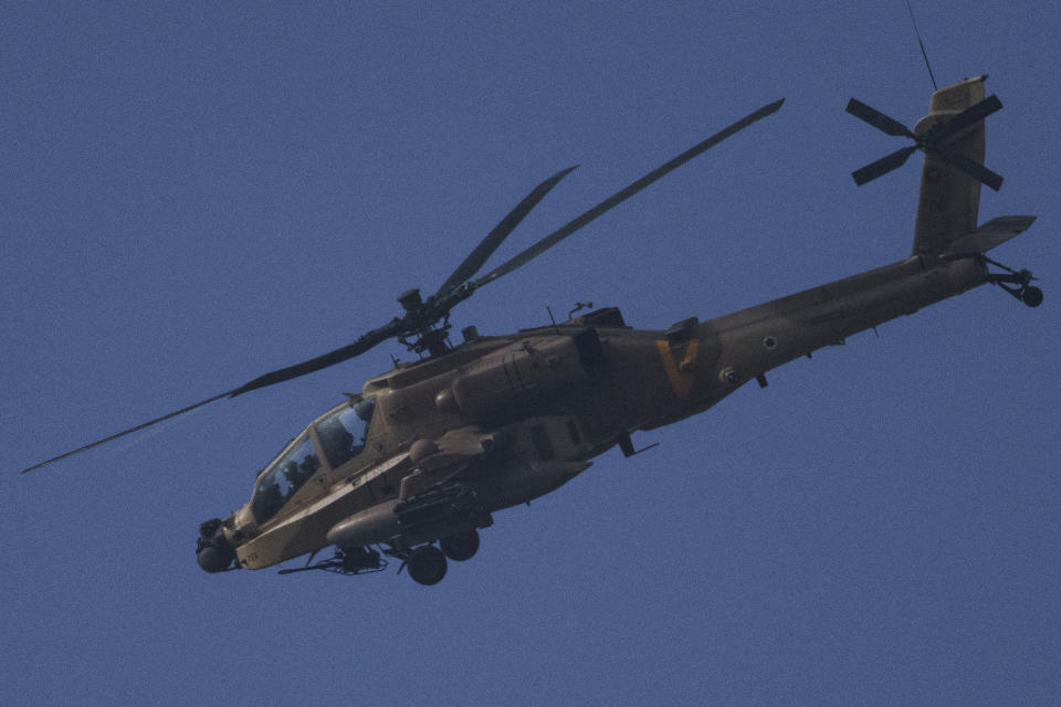 An Israeli Apache helicopter flies over Israeli-Gaza border, seen from southern Israel, Tuesday, Jan. 23, 2024. (AP Photo/Leo Correa)