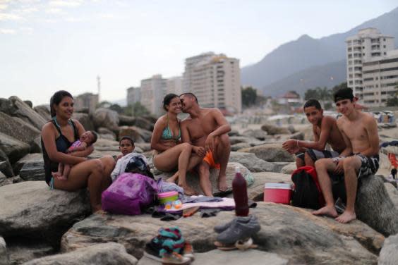 Leonel Martinez kisses his girlfriend as they spend a day at Coral beach (Reuters)