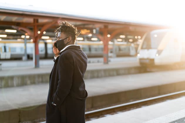 Handsome confident businessman on his way home from work. He is standing on the train station platform at sunset, waiting for his train. (Photo: luza studios via Getty Images)