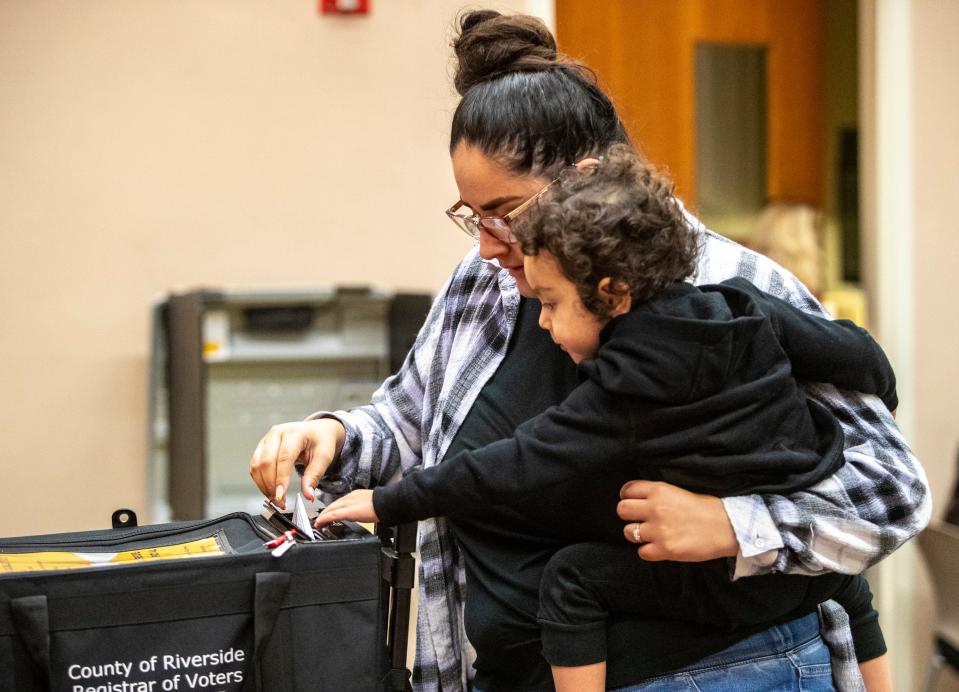 Alexis Arellano turns in her ballot to a drop-off box with help from her 2-year-old son AndrŽs Maldonado at the Cathedral City Public Library in Cathedral City, Calif., Tuesday, Nov. 8, 2022. 