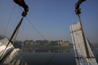 <p>Workers use machinery to remove the debris of a pedestrian bridge that collapsed in Morbi town of western state Gujarat, India, Monday, Oct. 31, 2022. The century-old cable suspension bridge collapsed into the river Sunday evening, sending hundreds plunging in the water in one of the country's worst accidents in years. (AP Photo/Ajit Solanki)</p> 