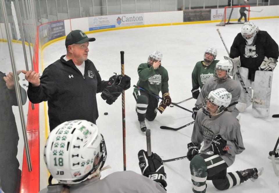 Canton girls hockey coach Dennis Aldrich points to a play diagram during practice last March.