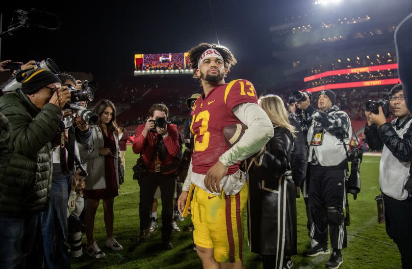 USC quarterback Caleb Williams (13) is swarmed by the media after beating Notre Dame