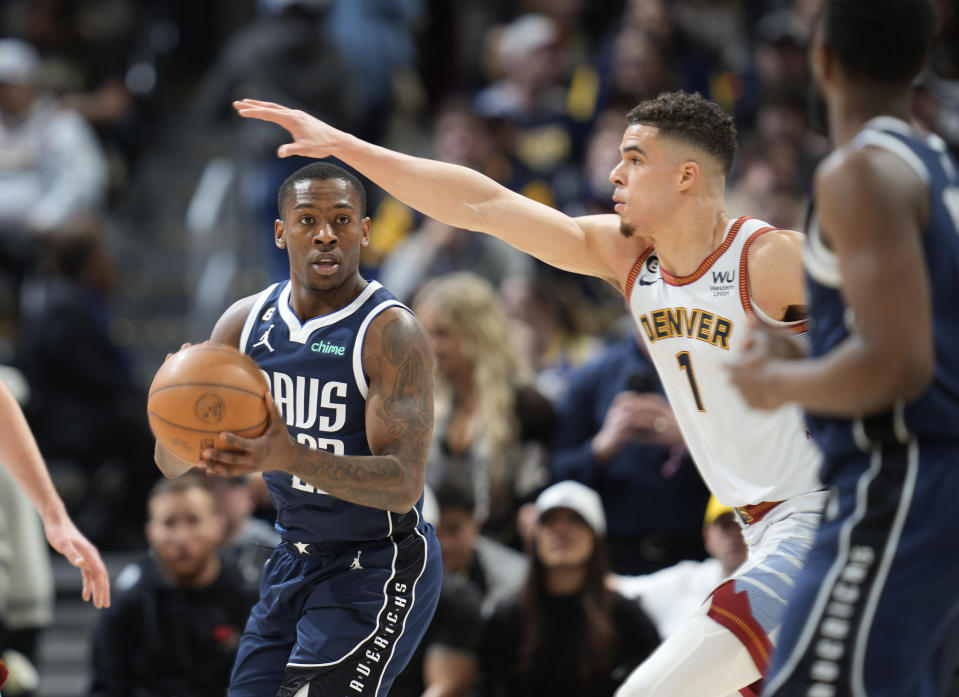 Dallas Mavericks guard McKinley Wright IV, left, looks to pass trhe ball as Denver Nuggets forward Michael Porter Jr. defends in the second half of an NBA basketball game Wednesday, Feb. 15, 2023, in Denver. (AP Photo/David Zalubowski)