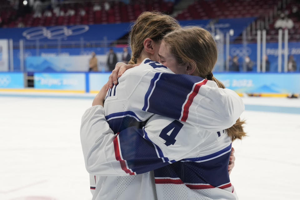 FILE - United States' Lee Stecklein and United States' Caroline Harvey, right, embrace after losing to Canada in the women's gold medal hockey game at the 2022 Winter Olympics, Thursday, Feb. 17, 2022, in Beijing. In 13 short months, United States defender Caroline Harvey has put aside a lack of playing time at the Beijing Winter Games to winning an NCAA Tournament title to close her freshman season at Wisconsin and establishing herself as key fixture on a young, retooling American team at the women's world hockey championships. (AP Photo/Petr David Josek, File)