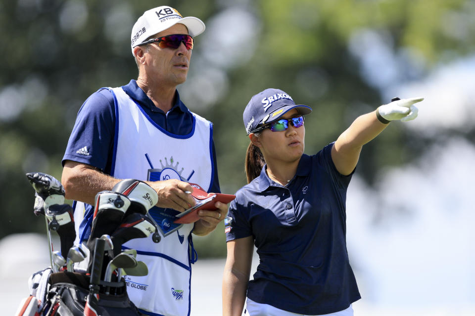 Nasa Hataoka, right, of Japan, points as she talks with her caddie Gregory Johnston on the 15th tee box during the first round of the LPGA Tour Kroger Queen City Championship golf tournament in Cincinnati, Thursday, Sept. 8, 2022. (AP Photo/Aaron Doster)