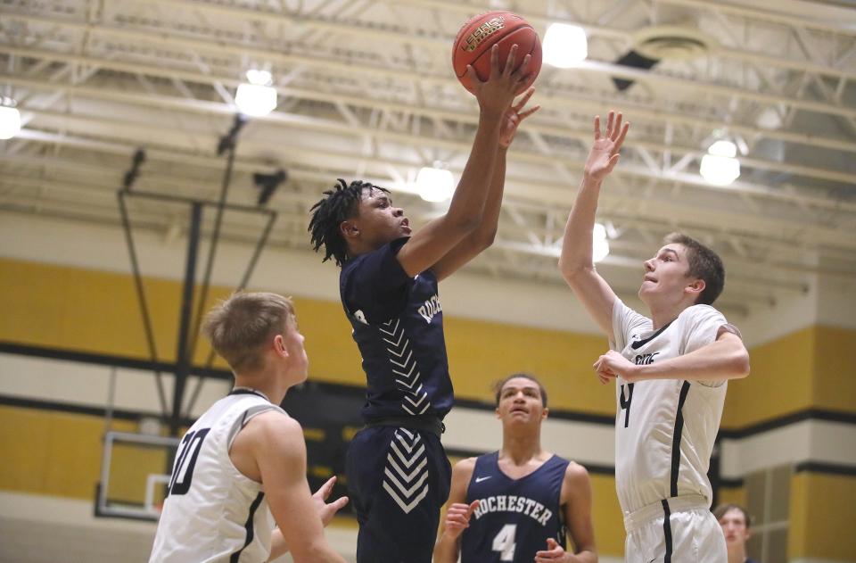 Rochester's Xavier Rigby (5) goes for a layup while being guarded by South Side's Jacob Strnisa (4) during the second half Friday night at South Side High School.