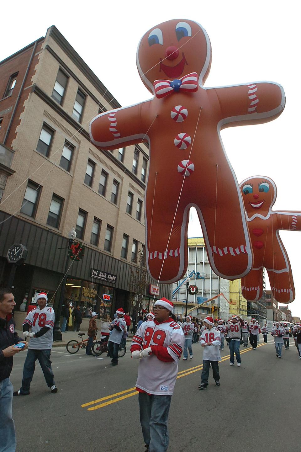 A Gingerbread Man and Woman float over the crowd in the Fall River Christmas Parade.