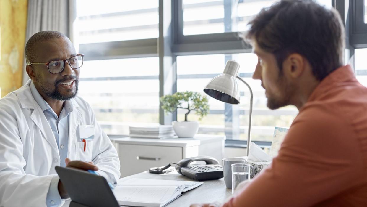 male doctor discussing with patient in clinic