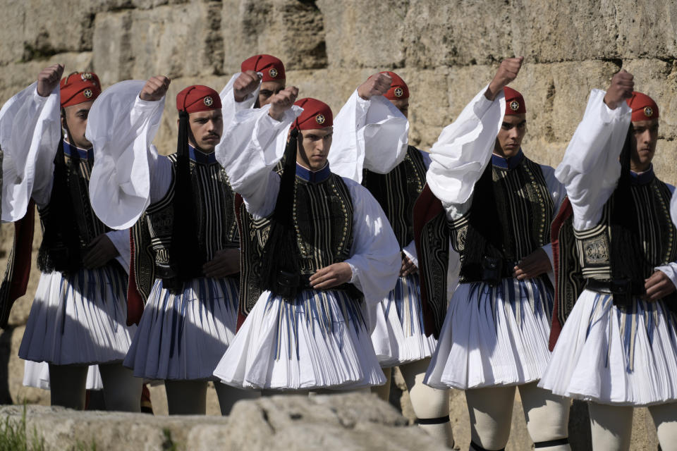 Greek Presidencial Guard soldiers march during the lighting of the Olympic flame at Ancient Olympia site, birthplace of the ancient Olympics in southwestern Greece, Monday, Oct. 18, 2021. The flame will be transported by torch relay to Beijing, China, which will host the Feb. 4-20, 2022 Winter Olympics. (AP Photo/Petros Giannakouris)