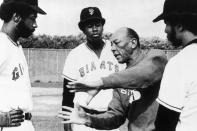 FILE - Former Olympic great Jesse Owens gestures while talking to San Francisco Giants baseball players, from left, Garry Maddox, Gary Matthews and Horace Speed during spring training drills in Casa Grande, Ariz., in this March 8, 1975, file photo. Pete Rose talks about facing Hall of Fame pitchers in the 1970s and 1980s. Gary Matthews, another big name from the 1970s said "A good day against those guys was two strikeouts and two walks.” (AP Photo/Robert H. Houston, File)