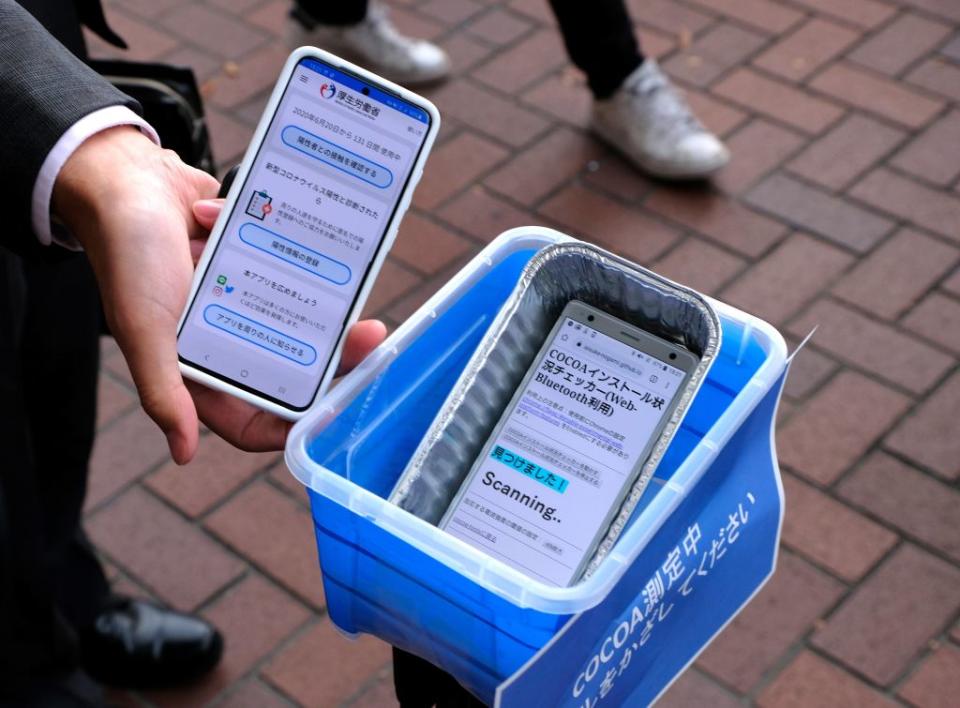 A COCOA, COVID-19 Contact-Confirming Application (L), is displayed next to its detection device (R) at an entrance of the Yokohama Stadium, which will host baseball and softball games during the Tokyo Olympics, prior to a professional baseball game in Yokohama, Kanagawa prefecture on October 30, 2020.<span class="copyright">KAZUHIRO NOGI/AFP via Getty Images</span>