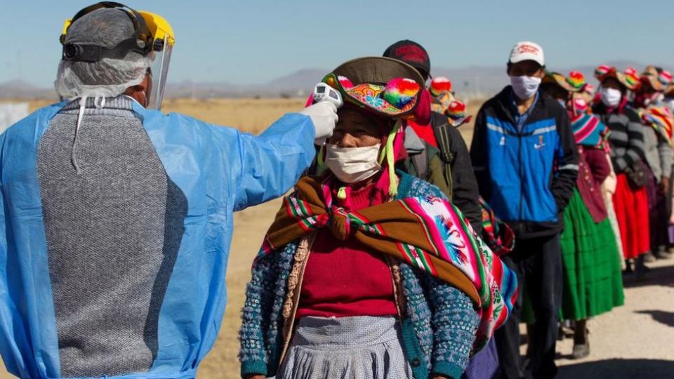 Personas hacen fila en Puno, Bolivia, para tomarse la temperatura.