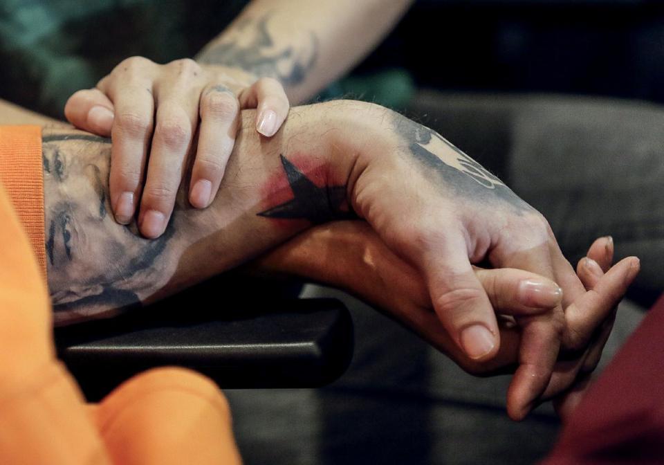 Rod Daily, left, and his girlfriend, Cameron Bay, both adult film performers who became infected with HIV while working in the adult industry, hold hands as they take questions from the media during a news conference on Wednesday, Sept. 18, 2013 in Los Angeles. The actors told reporters that a recent outbreak of HIV infections proves that industry officials are wrong when they say testing performers for HIV and other diseases every 14 days is sufficient. Bay and Daily say they learned days apart last month that they were infected. (AP Photo/Damian Dovarganes)