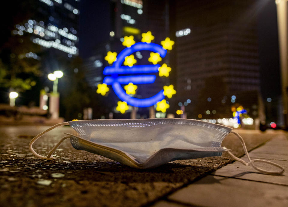 A face mask was left behind near the Euro sculpture in Frankfurt, Germany, early Monday, Oct. 19, 2020. (AP Photo/Michael Probst)