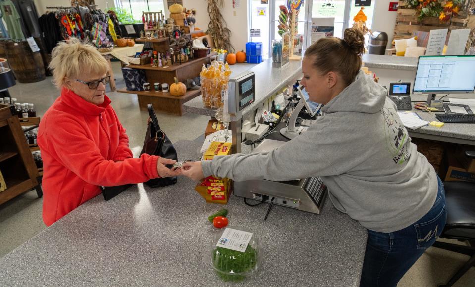 Pam Sherrick, left, purchases lettuce from Melinda Carroll at Bodwéwadmi Ktëgan, the Forest County Potawatomi farm on Oct. 23, in Laona.