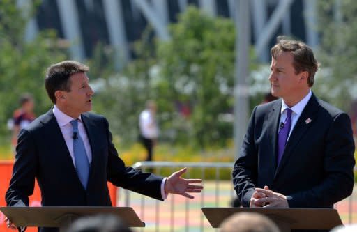 El presidente del comité olímpico organizador de los Juegos de Londres-2012, Sebastian Coe (izq), en una rueda de prensa conjunta con el primer ministro británico, David Cameron, este jueves en el parque olímpico de la capital británica, a un día del inicio oficial de la competición. (AFP | Saeed Khan)