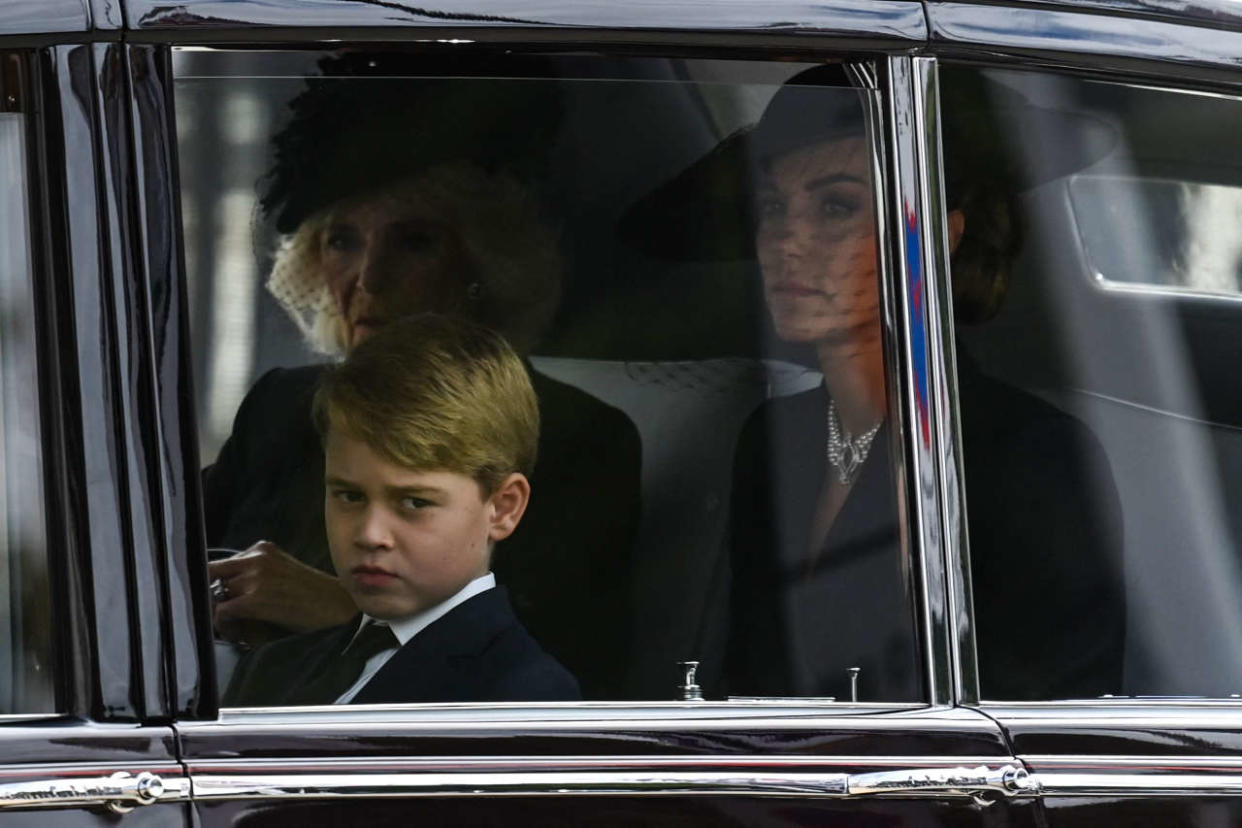 Britain's Prince George of Wales (L), Britain's Camilla, Queen Consort (C) and Britain's Catherine, Princess of Wales (R) leave Westminster Abbey in London on September 19, 2022, after the State Funeral Service for Britain's Queen Elizabeth II. (Photo by Alain JOCARD / POOL / AFP)