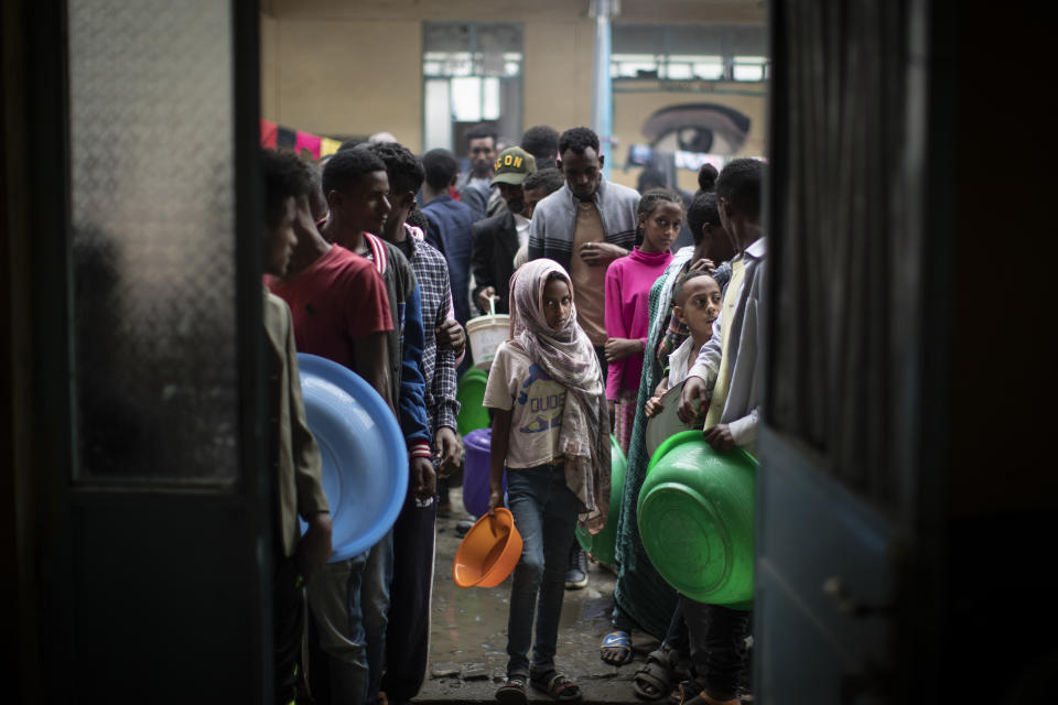 Displaced Tigrayans queue to receive food at the Hadnet General Secondary School which has become a makeshift home to thousands displaced by the conflict, in Mekele, in the Tigray region of northern Ethiopia Wednesday, May 5, 2021. The Tigray conflict has displaced more than 1 million people, the International Organization for Migration reported in April, and the numbers continue to rise. (AP Photo/Ben Curtis)