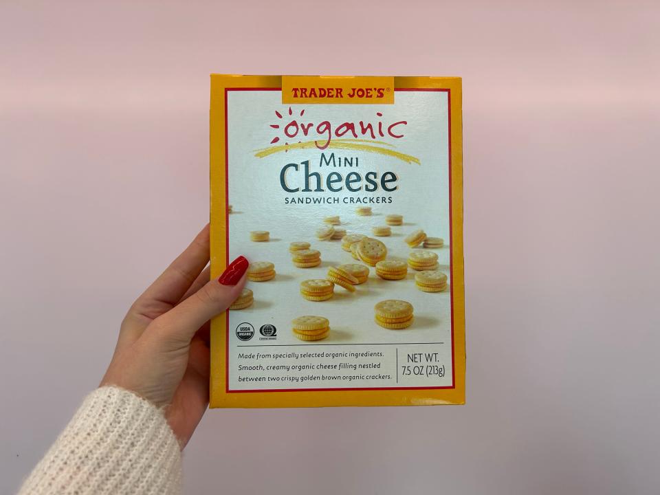 The writer holds Trader Joe's organic cheese sandwich crackers