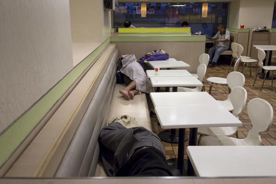 Men sleep at a 24-hour McDonald's restaurant as people read newspapers behind them (R), in Hong Kong, China November 11, 2015. A large number of homeless people sleeping on the street has long been been a problem in Hong Kong mainly due to its high rents and soaring property prices. In recent years, the opening of McDonald's 24-hour fast food restaurants all over the city have become popular alternatives for homeless people known as McRefugees or McSleepers to spend the night in a safer and more comfortable way than on the street. McDonaldâ€™s Hong Kong said in a statement that it is accommodating to people staying long in the restaurant for their own respective reasons, while striking a good balance to ensure that customers enjoy their dining experience. REUTERS/Tyrone Siu