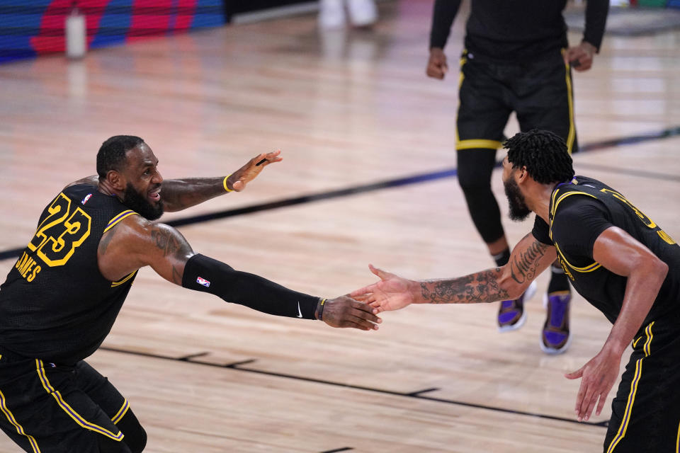 Los Angeles Lakers' LeBron James (23) celebrates with Anthony Davis during the second half of an NBA conference semifinal playoff basketball game against the Houston Rockets Sunday, Sept. 6, 2020, in Lake Buena Vista, Fla. (AP Photo/Mark J. Terrill)