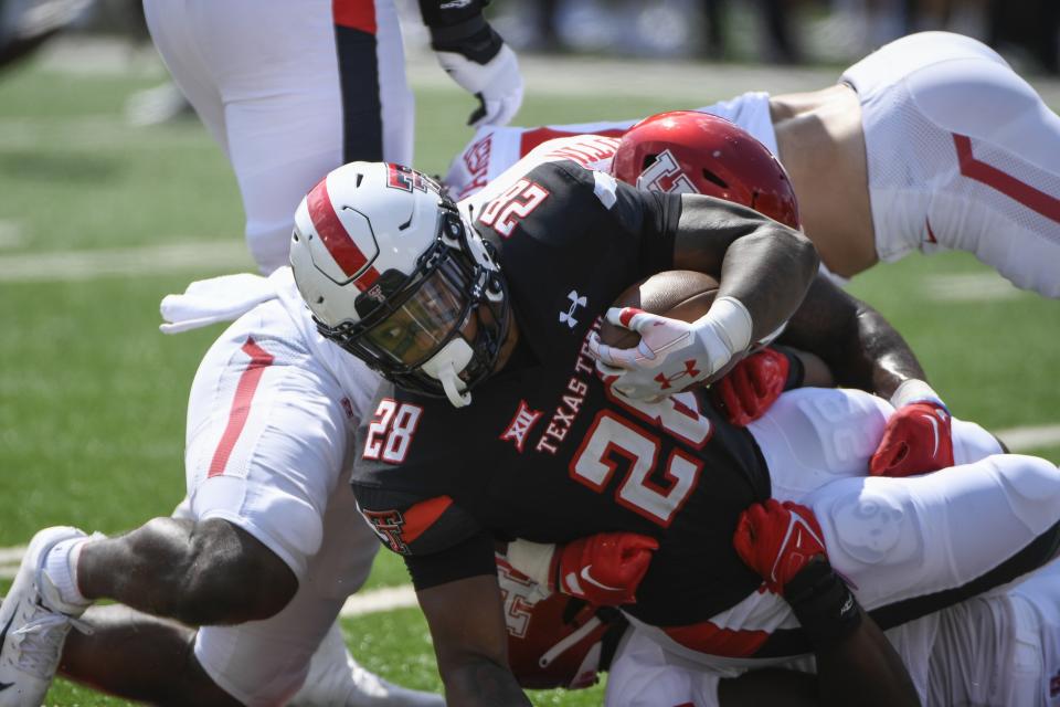 Texas Tech running back Tahj Brooks (28) is brought down by multiple Houston defenders during the first half of an NCAA college football game Saturday, Sept. 10, 2022, in Lubbock, Texas. (AP Photo/Justin Rex)