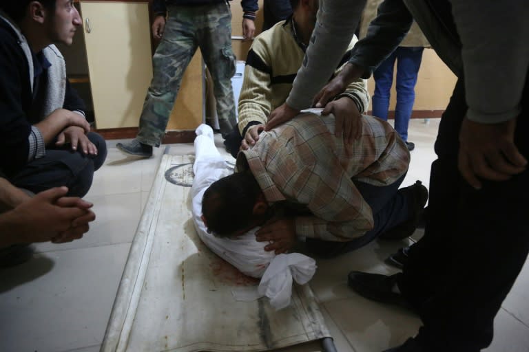 A Syrian man mourns over the body of a child at a makeshift hospital following the reported government shelling of a school in the rebel-held besieged town of Jisreen, east of the capital Damascus, on October 31, 2017