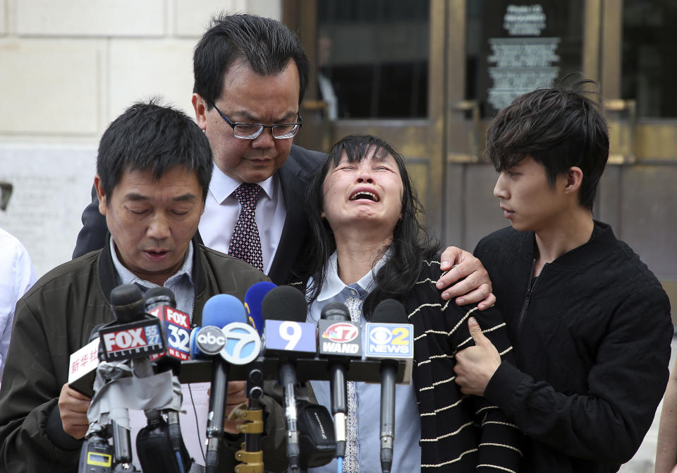 Lifeng Ye, the mother of slain University of Illinois scholar Yingying Zhang, cries out in grief as her husband Ronggao Zhang, far left, addresses the media after a jury found Brendt Christensen guilty of her murder Monday, June 24, 2019 outside the U.S. Federal Courthouse in Peoria, Ill. Consoling her is her son Zhengyang Zhang, far right, and family friend Dr. Kim Tee. (Terrence Antonio James/Chicago Tribune via AP)