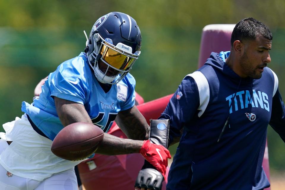 Tennessee Titans outside linebacker Arden Key, left, runs through pass rush drills with outside linebackers coach Ryan Crow, right, during practice at the NFL football team's training facility Tuesday, June 6, 2023, in Nashville, Tenn. (AP Photo/George Walker IV)