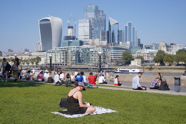 People enjoying the warm weather in Potters Field near Tower Bridge, London