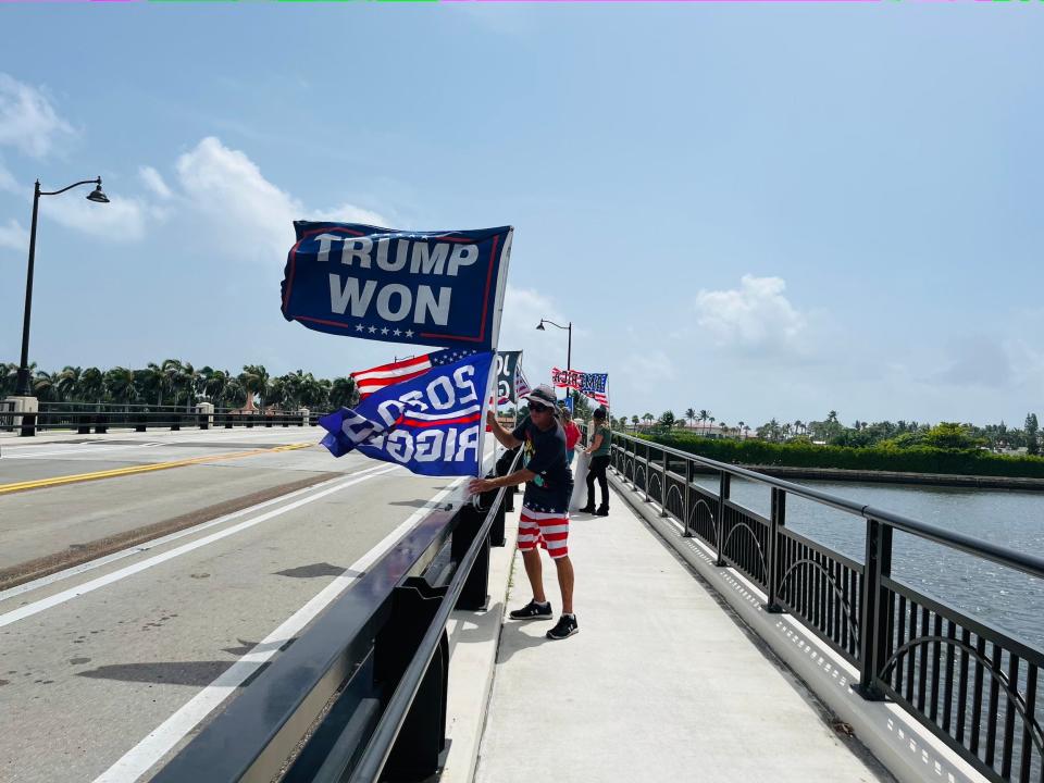 Trump supporter holds a "Trump won" flag outside of Mar-a-Lago.