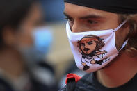 Greece's Stefanos Tsitsipas wears a face mask with his own caricature prior to his third round match of the French Open tennis tournament against Slovenia's Aljaz Bedene at the Roland Garros stadium in Paris, France, Saturday, Oct. 3, 2020. (AP Photo/Michel Euler)