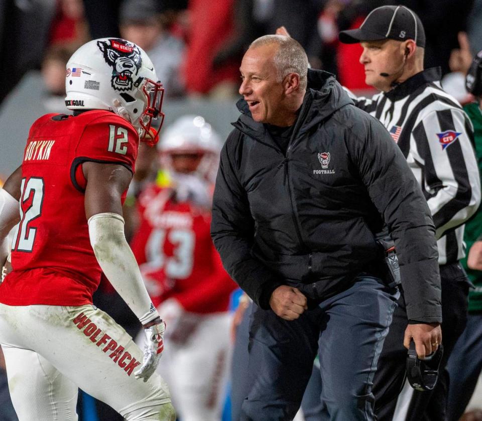 N.C. State coach Dave Doeren celebrates with Devan Boykin (12) after he intercepted a Drake Maye pass to secure the Wolfpack’s 39-20 over North Carolina victory on Saturday, November 25, 2023 at Carter-Finley Stadium in Raleigh, N.C.